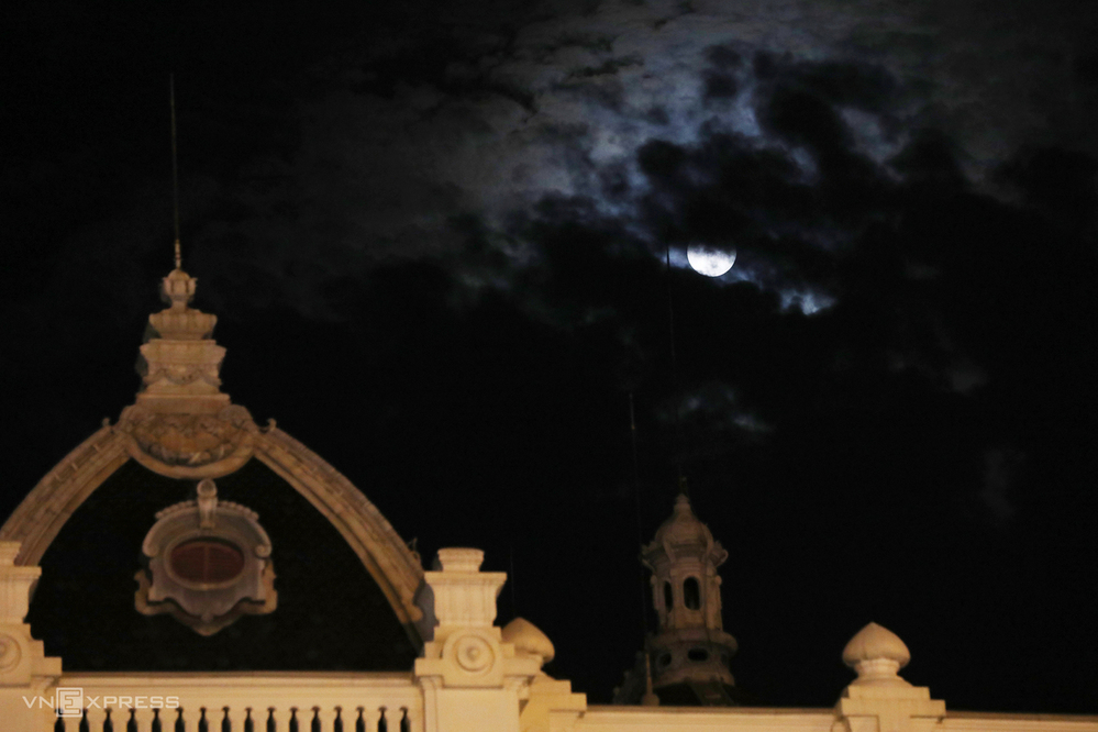 Mặt Trăng lấp ló giữa đám mây trên phố Tràng Tiền. Q.Hoàn Kiếm. (Ảnh: VnExpress)